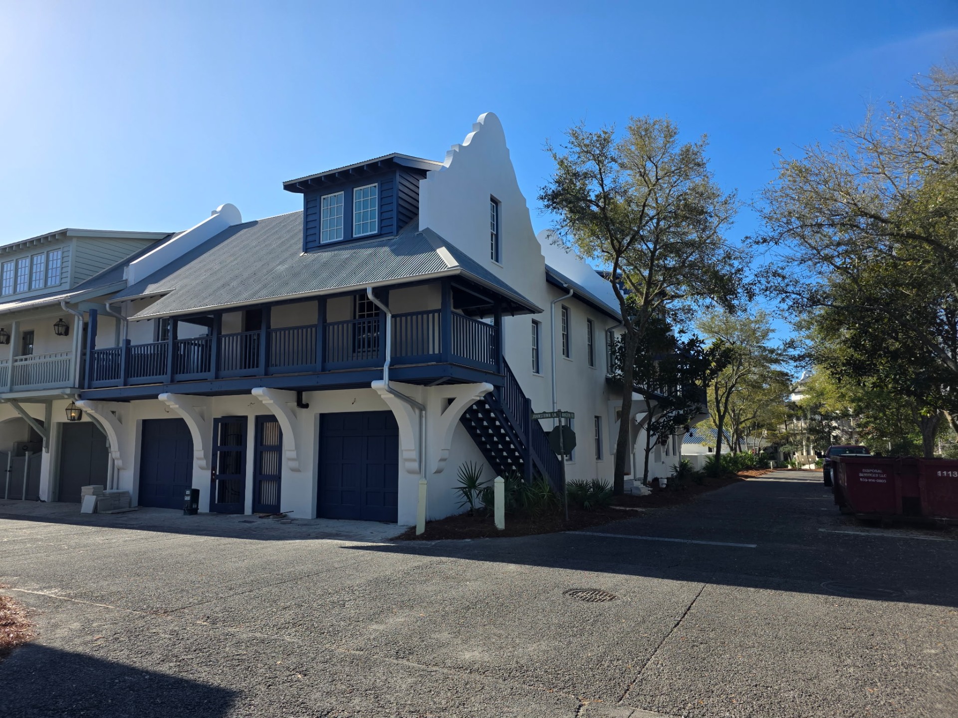 White carriage house with navy blue trim and shutters