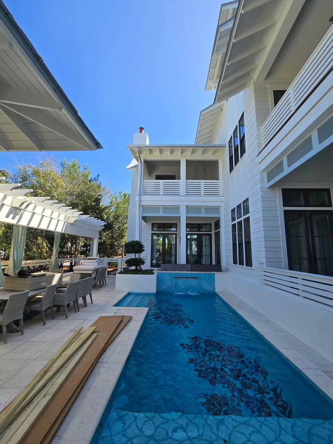 Lap pool between two coastal homes with pergola